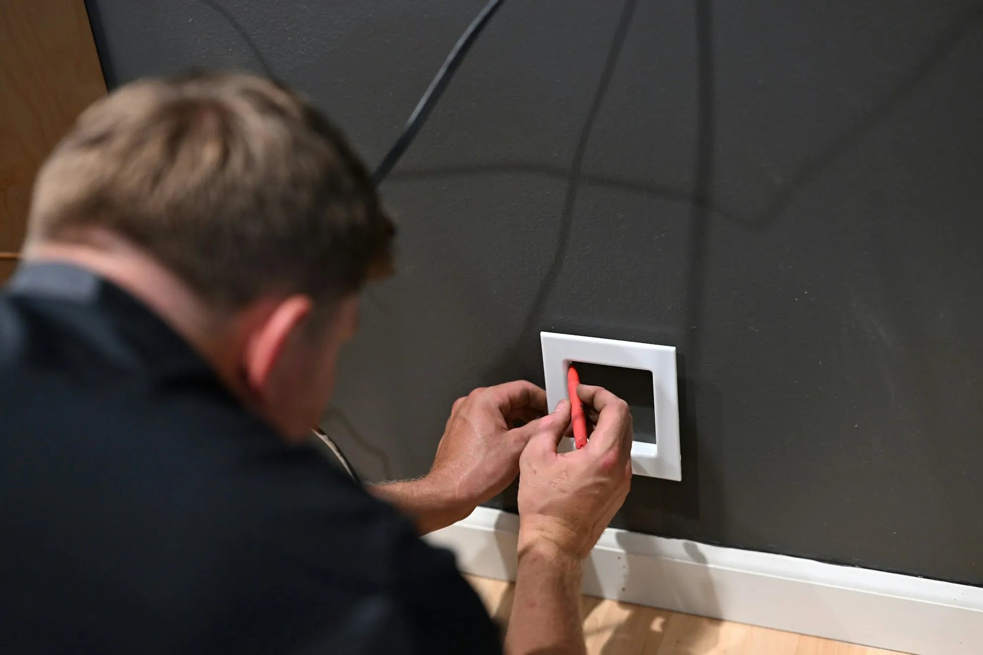 Electrician fixing a cover plate onto a newly wired wall switch