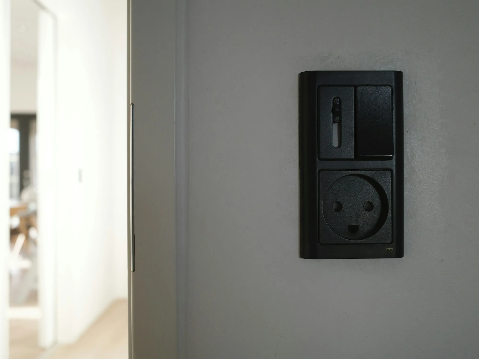 Black wall switch and socket on a white wall