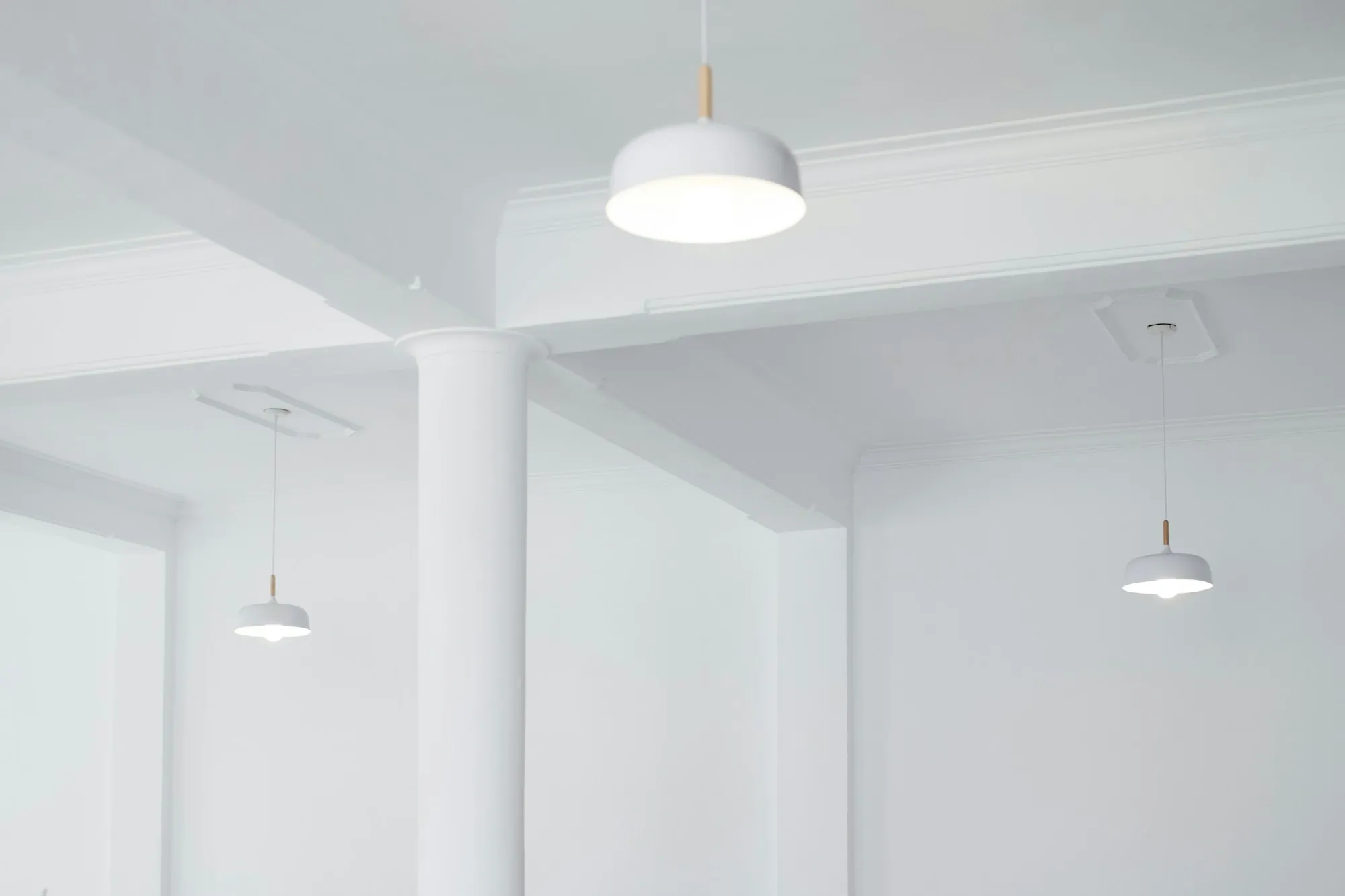 Bright renovated room with white walls and pendant ceiling lights